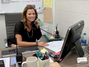 Mrs. Vienna taking a call at her desk. 