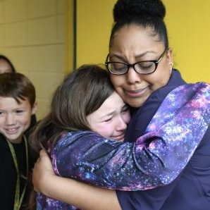 Student hugging her teacher.